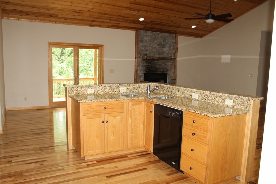 open concept, granite countertops, stacked rock gas log fireplace